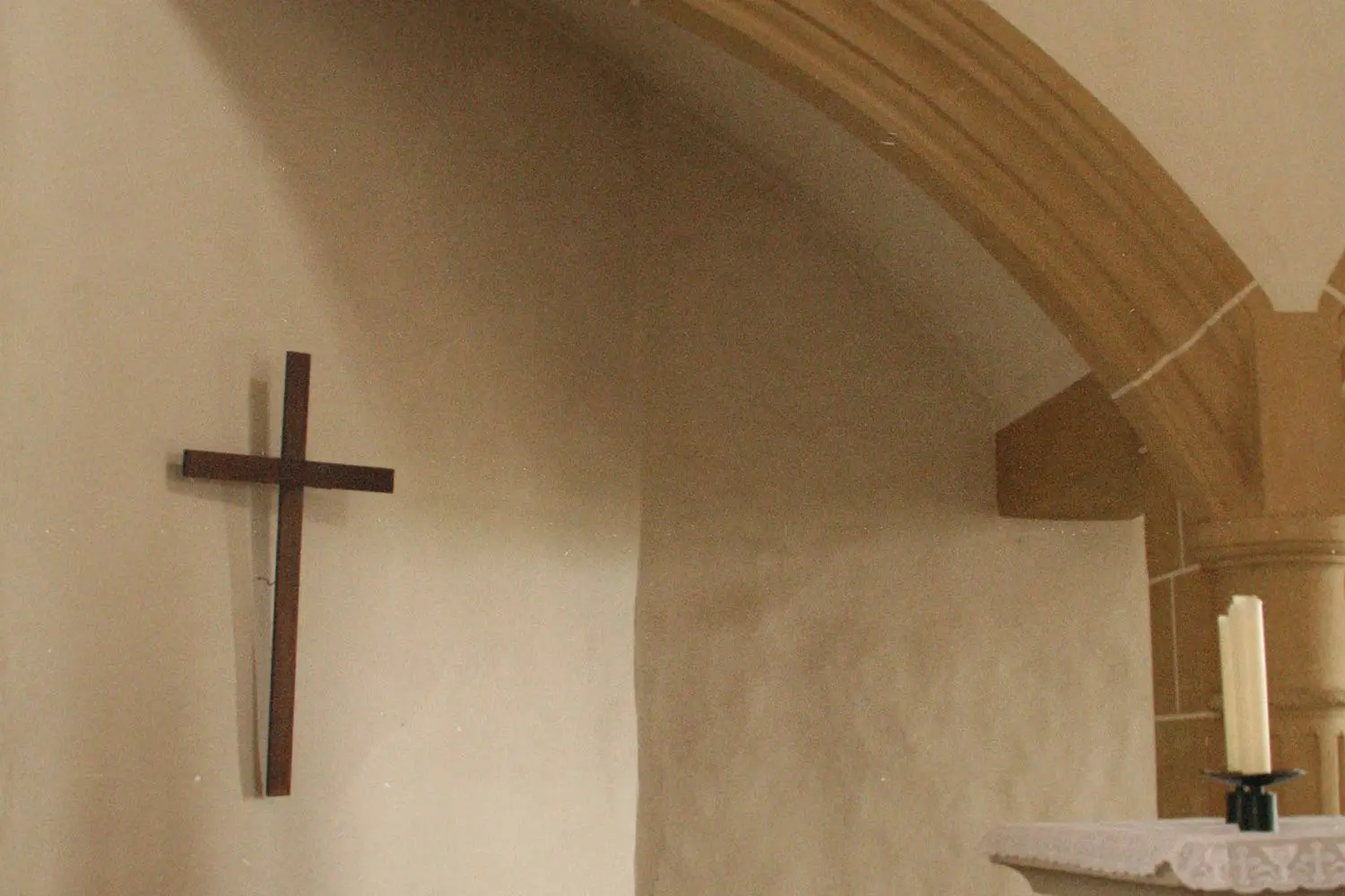 A cross on a wall of a small stone church