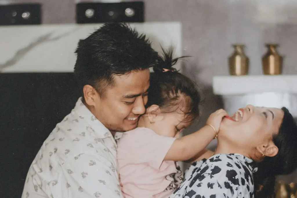 Happy parents in the kitchen playing with their toddler daughter