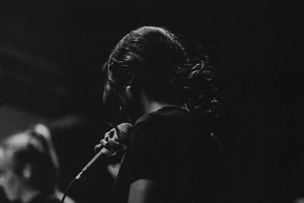 Live-Free-From-Fear-4-Bold-Steps-KCM - KCM Blog Woman holding a microphone worshipping