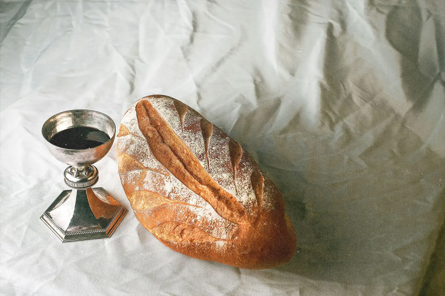Table with a chalice of wine and loaf of bread