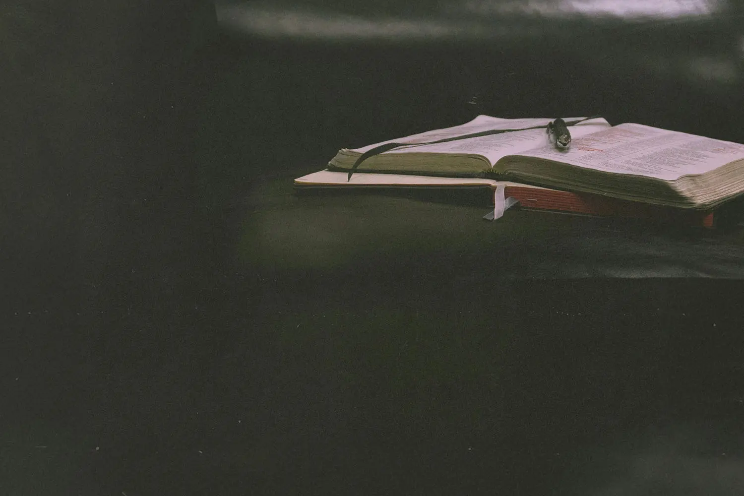 An open Bible and notebook on a table