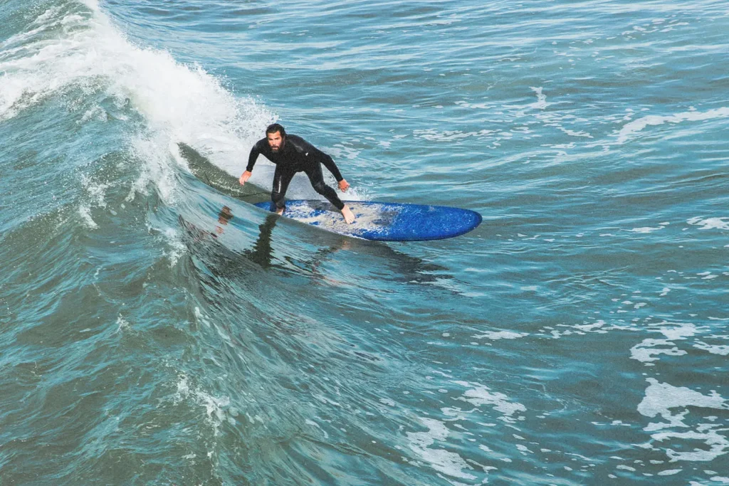 Man riding a wave on a blue surfboard