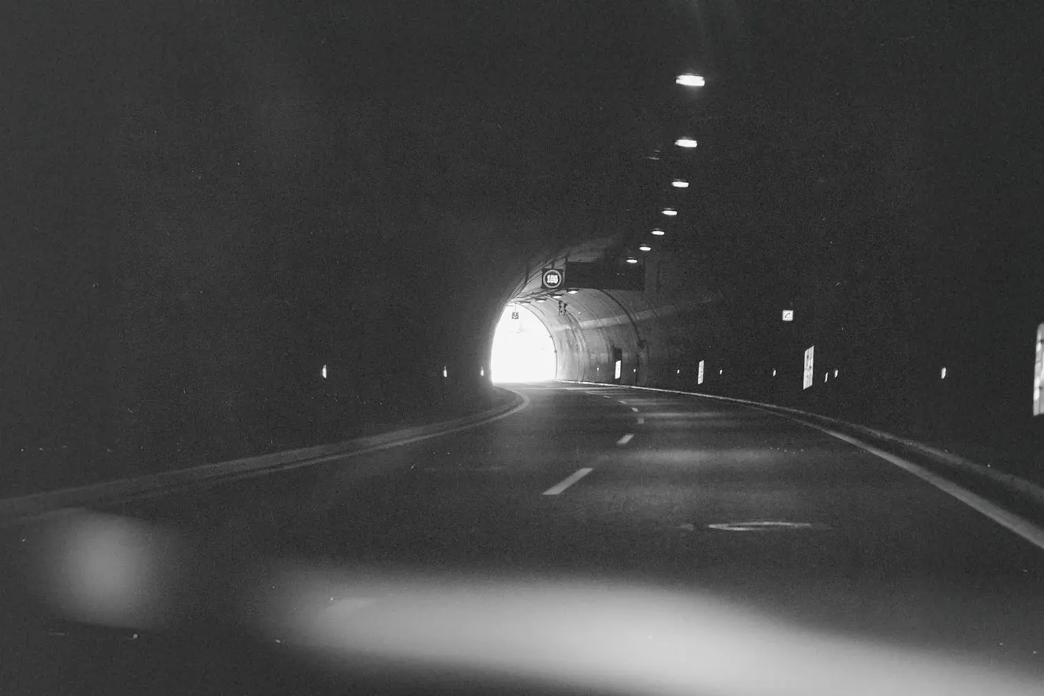Car driving through a dimly lit tunnel