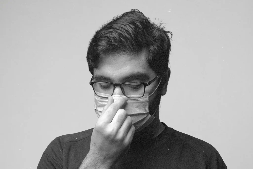 guy in a mask holding his nose