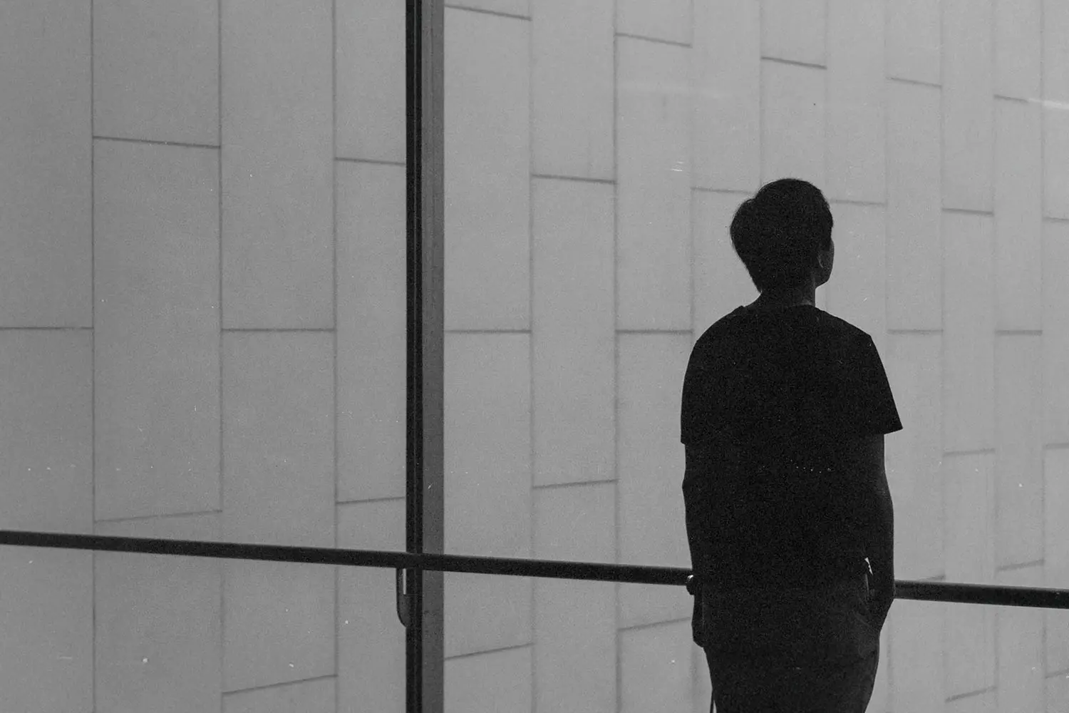 Single man standing at a glass window