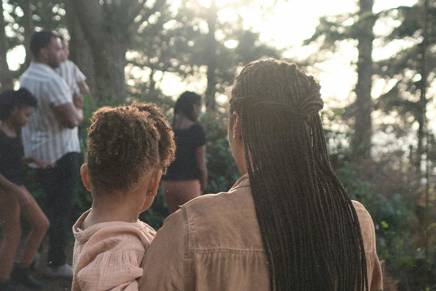 women carrying a child walking toward more people