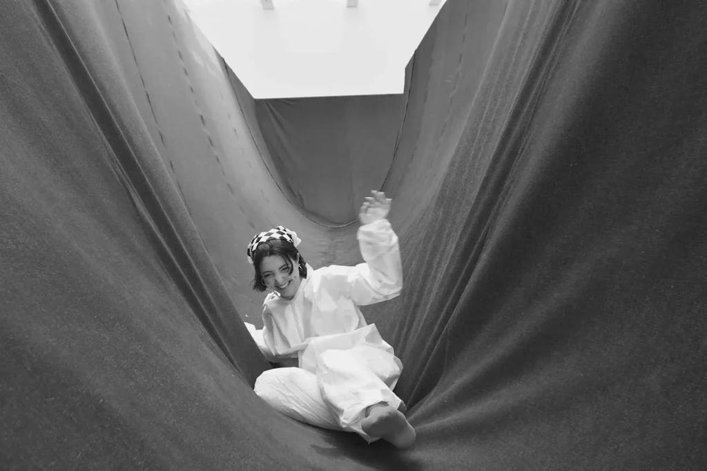 girl sliding through fabric curved like a slide