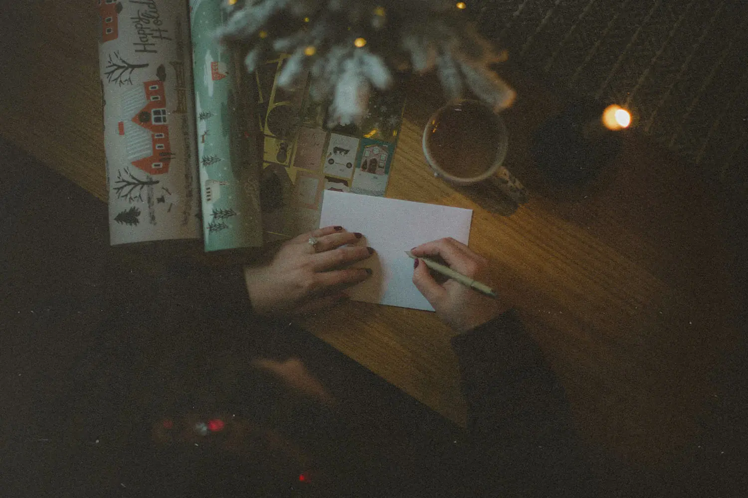 person writing a note next to wrapping paper