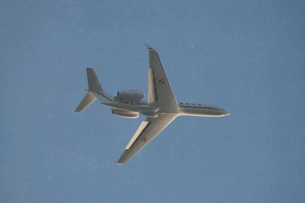 Airplane flying through cloudless blue sky