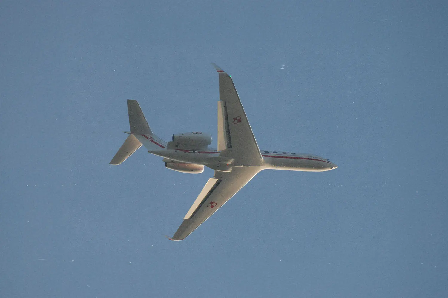 Airplane flying through cloudless blue sky