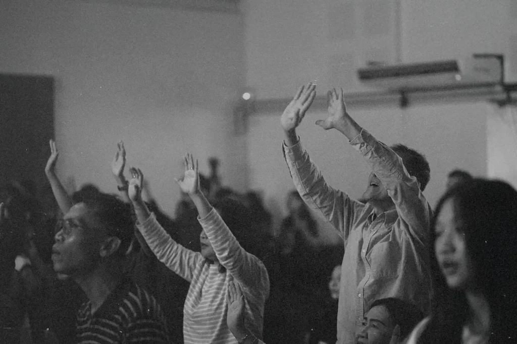 Crowd of people lifting hands and heads in worship