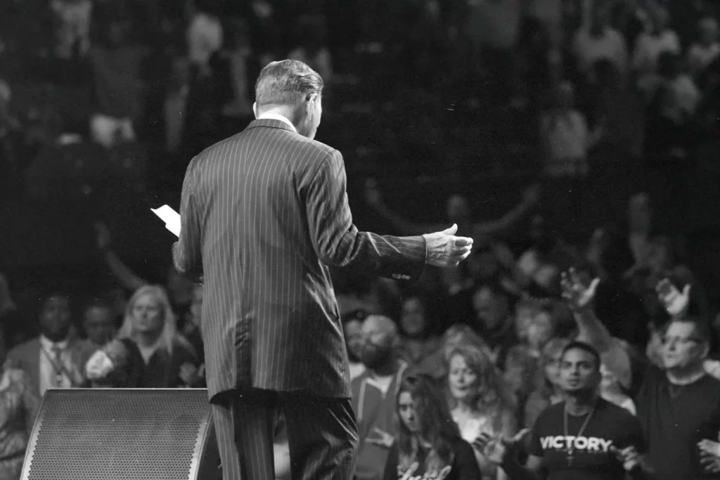 Back of Kenneth Copeland preaching to an audience