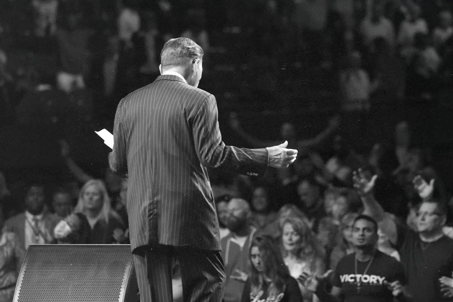 Back of Kenneth Copeland preaching to an audience