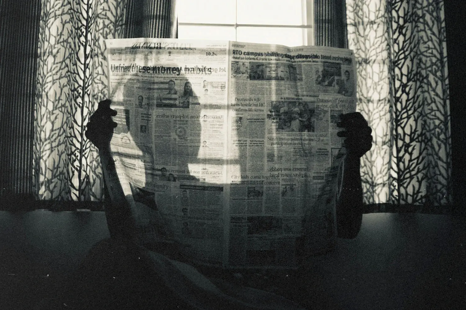 Silhouette of person holding a newspaper
