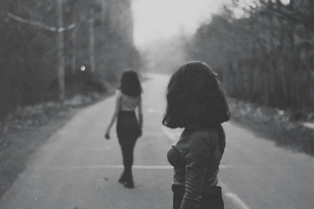 Young woman walking away from another woman