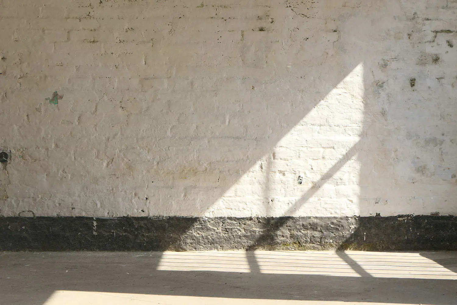 Shadow of window panes on a concrete wall