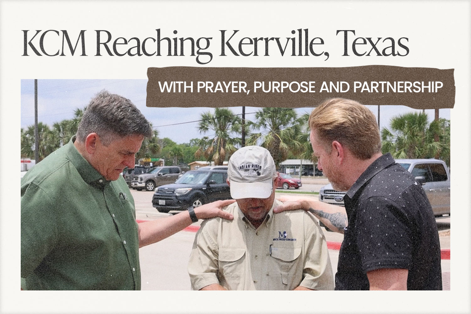 On a sunny day, two men are laying their hands on another man's shoulders, praying for him, while standing in a parking lot.