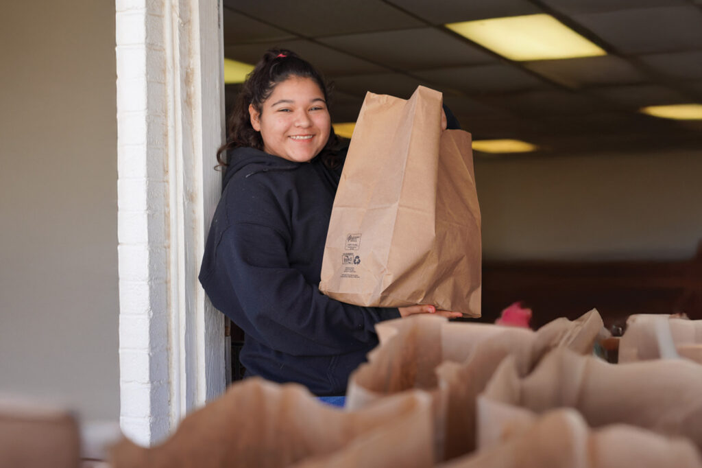 A worker at Life Unlimited Ministries carries groceries for those in need.