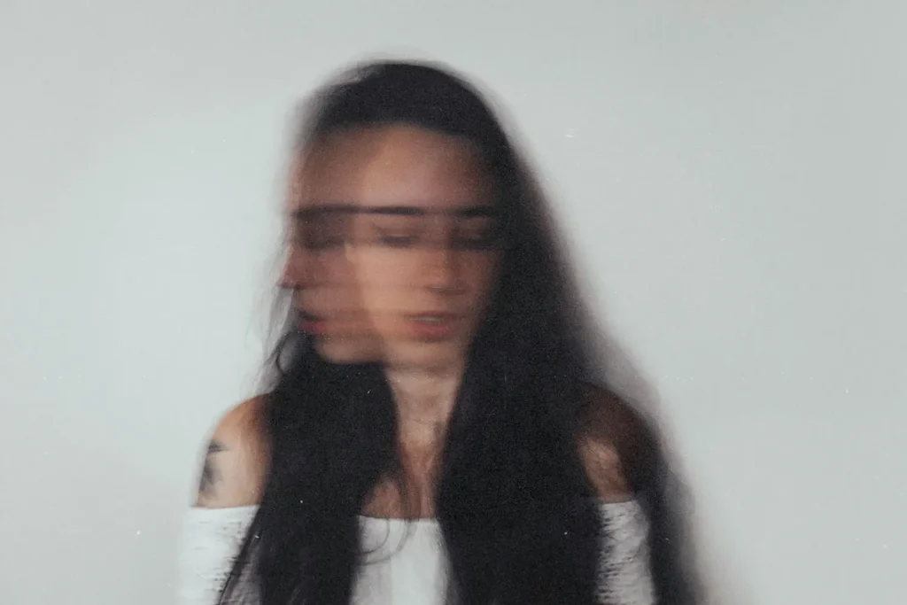 Blurred image of woman shaking her head with her eyes closed