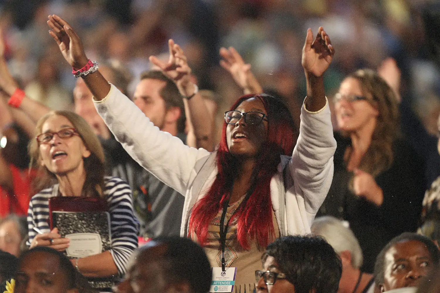 Woman with eyes closed and hands raised in worship