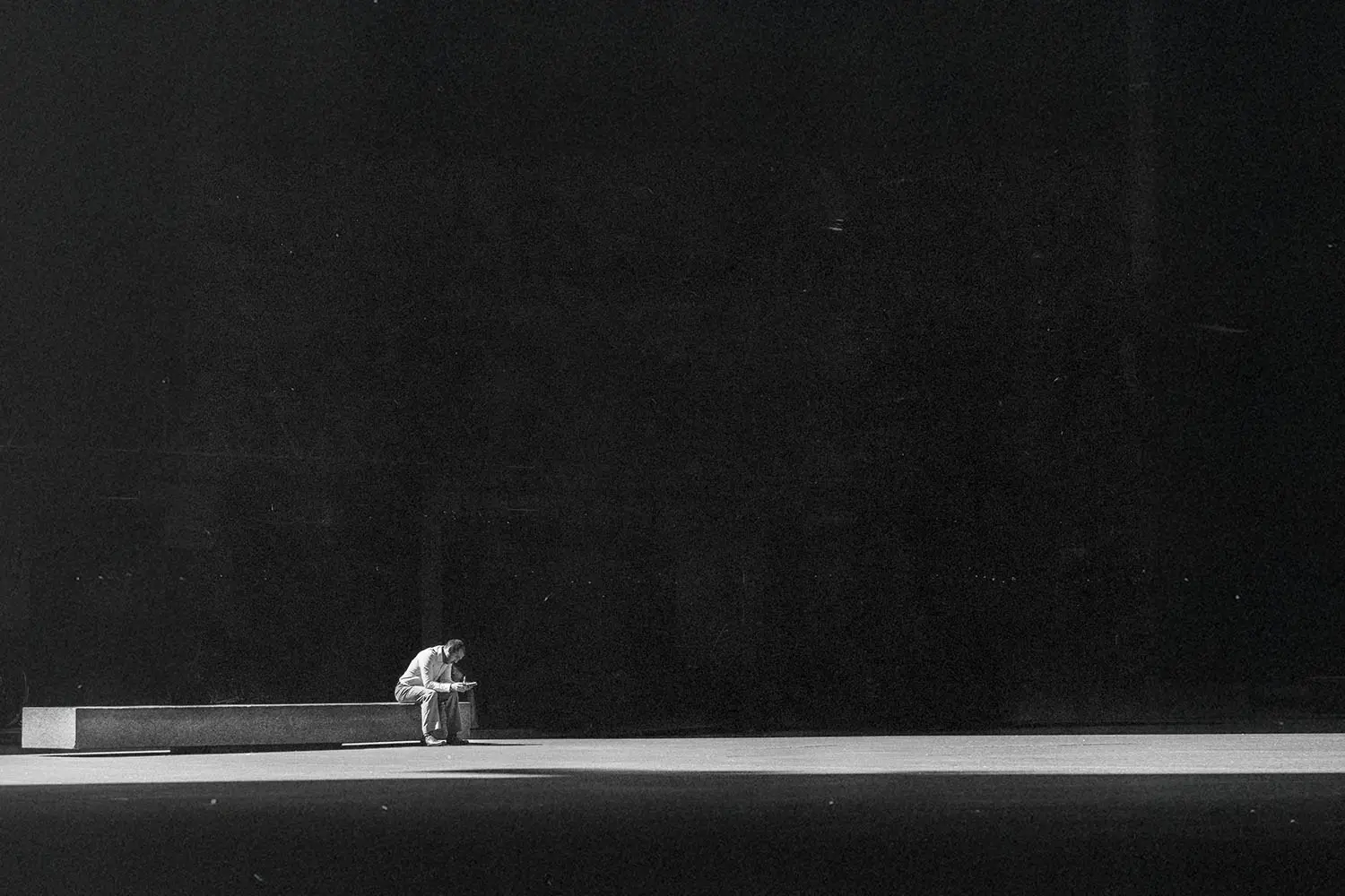 Spotlight shining on a man sitting on a big stage