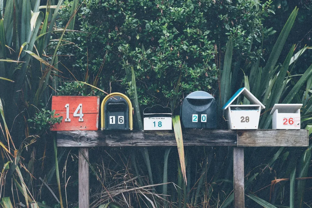 Line of mailboxes of different shapes, colors, and numbers