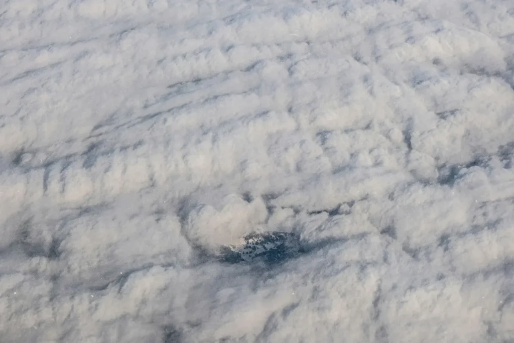 Shot of clouds from above with small town peeking through