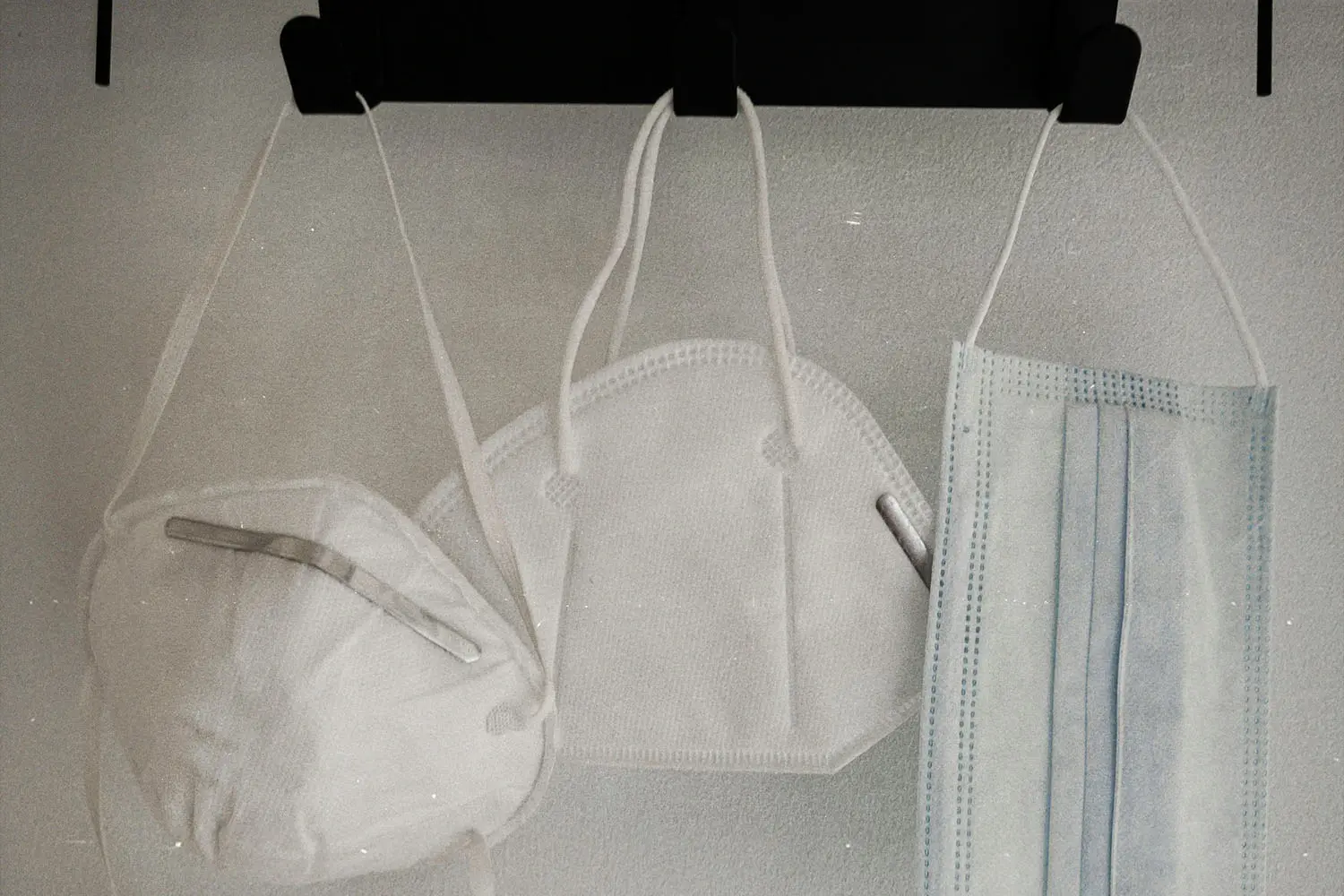 three hanging face masks