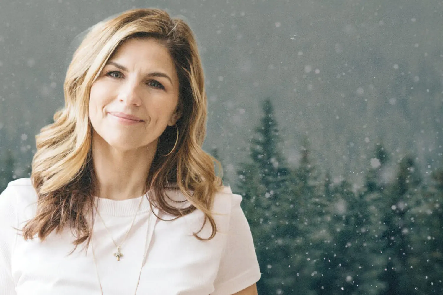 Kellie Copeland smiling in front of winter forest background