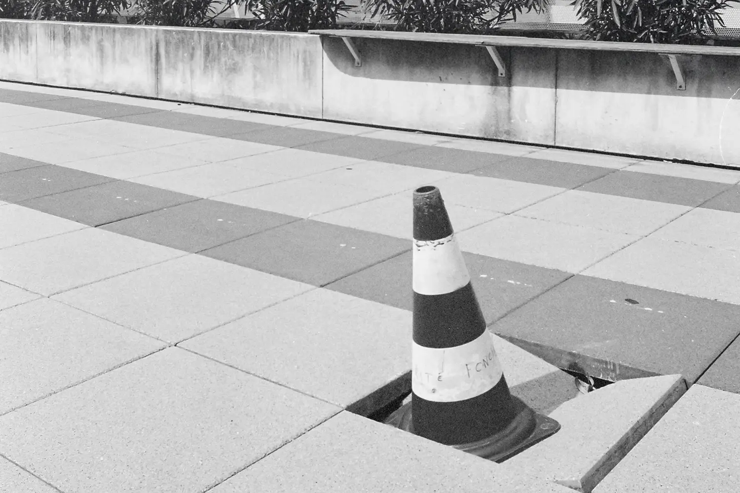 caution cone in a broken block of pavement