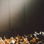 crowd of people with their hands raised in worship