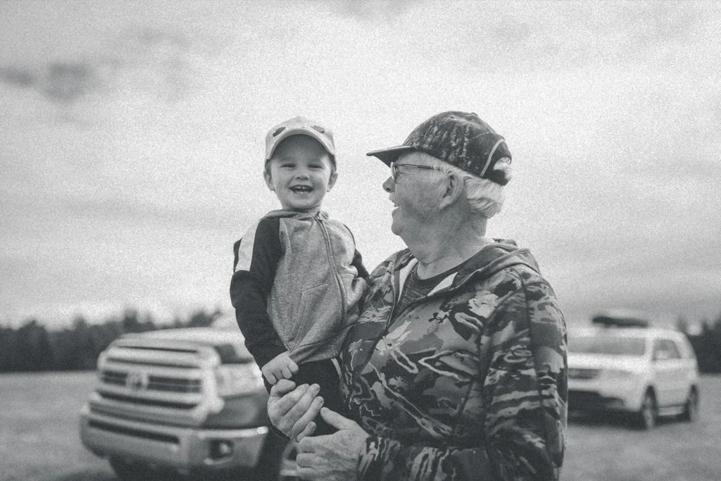 older man holding a smiling little boy