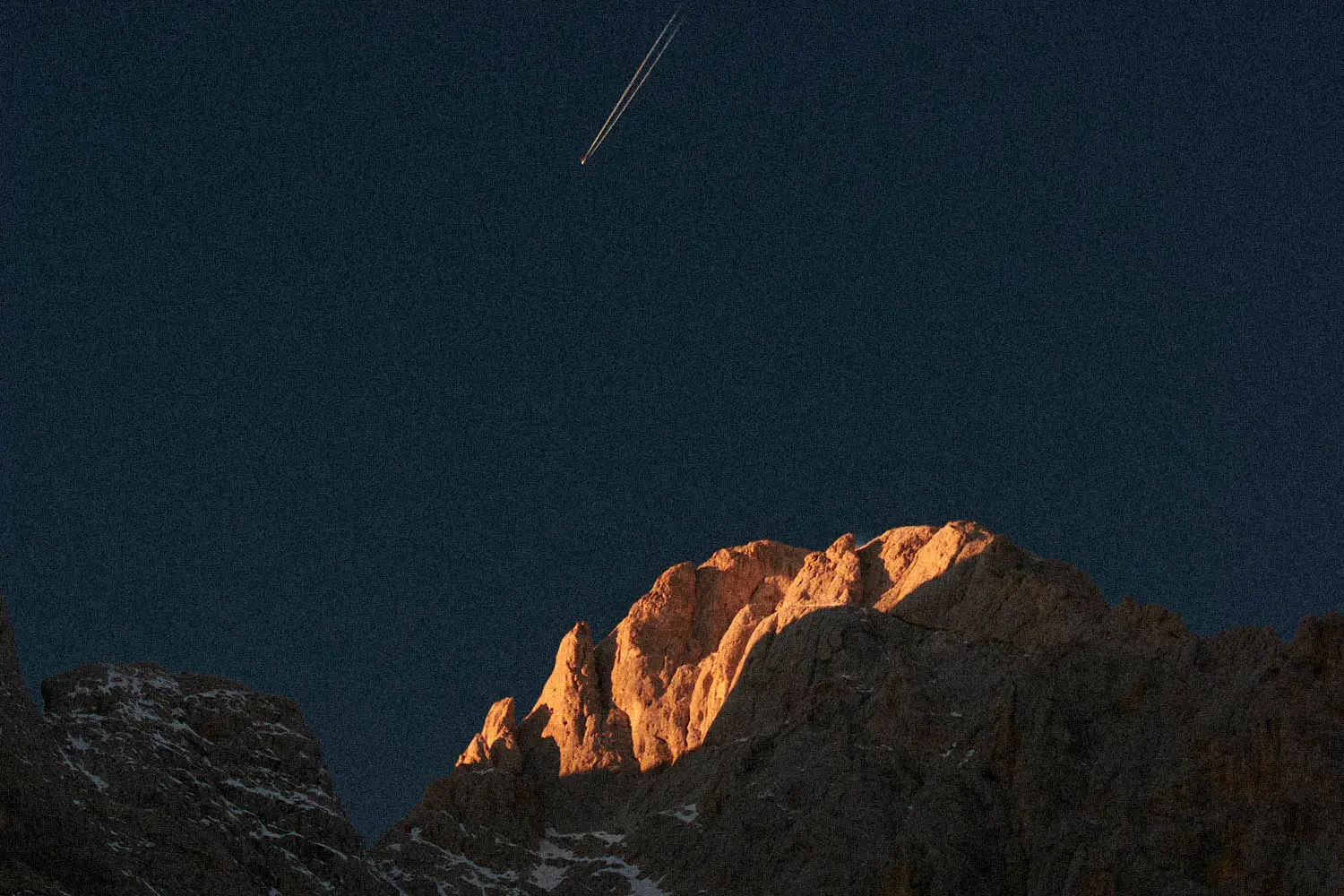 plane in the sky over a mountain