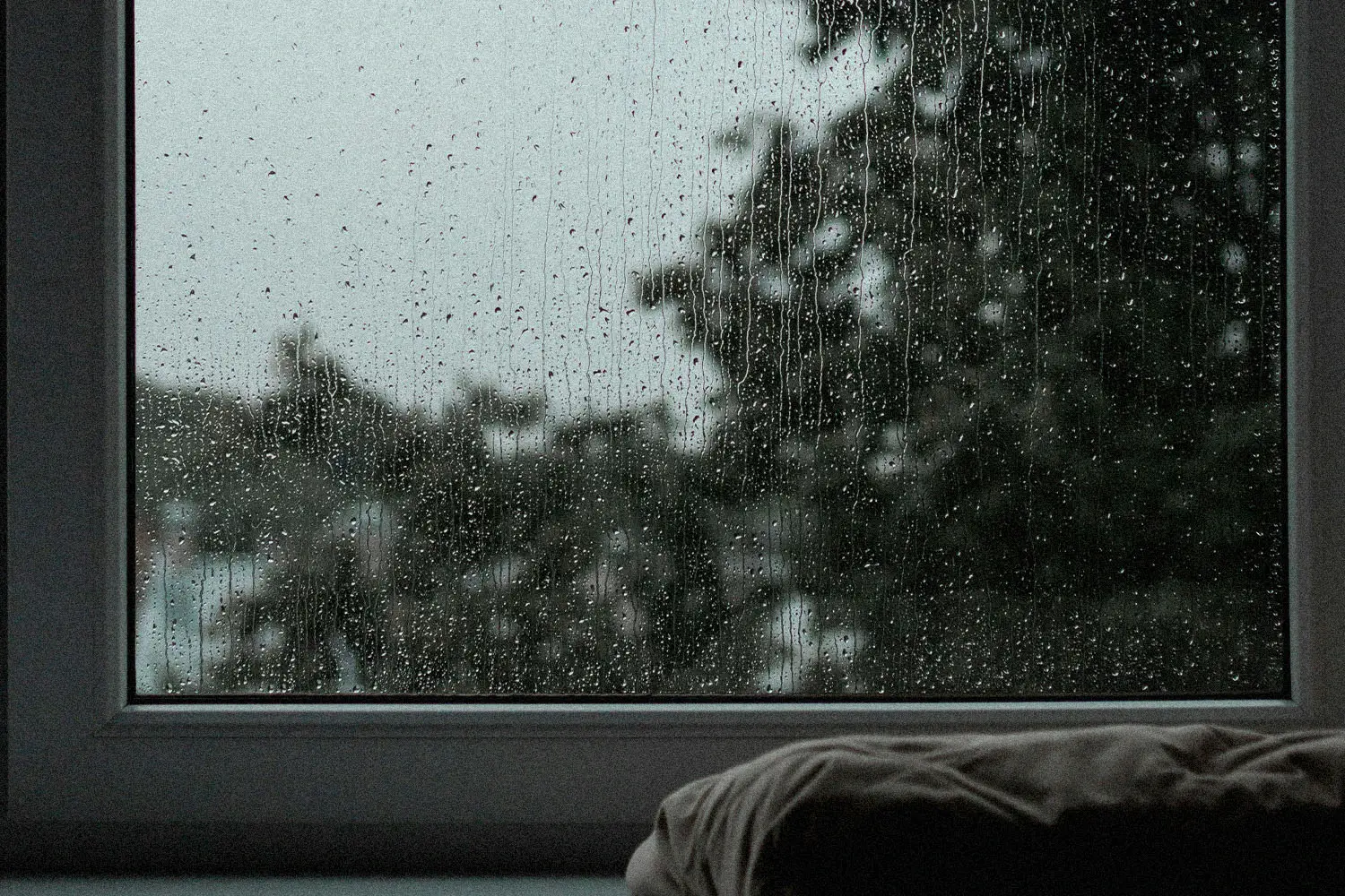 rain streaks down a closed window