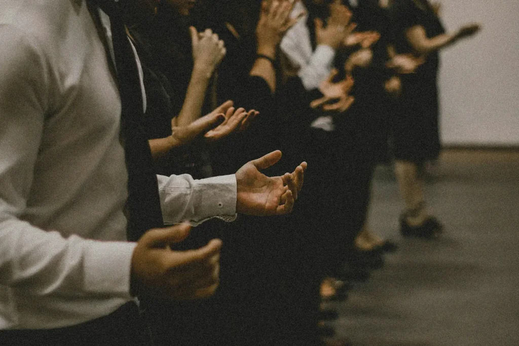 Line of people with hands lifted in prayer