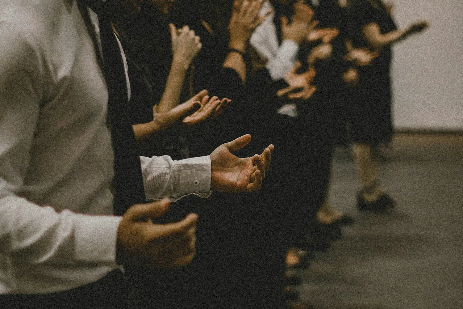 Line of people with hands lifted in prayer