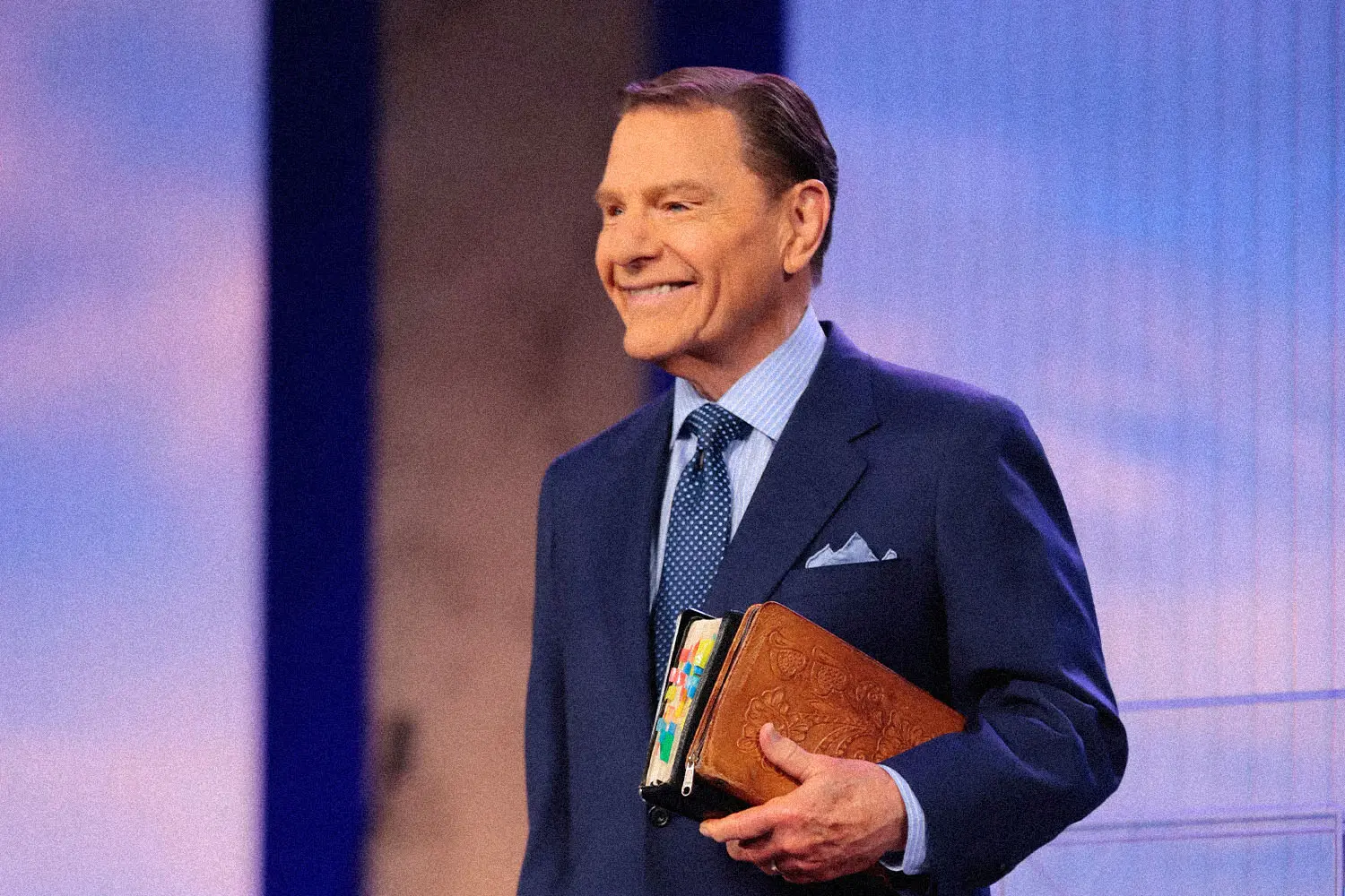 Kenneth Copeland smiling holding his Bible under his arm