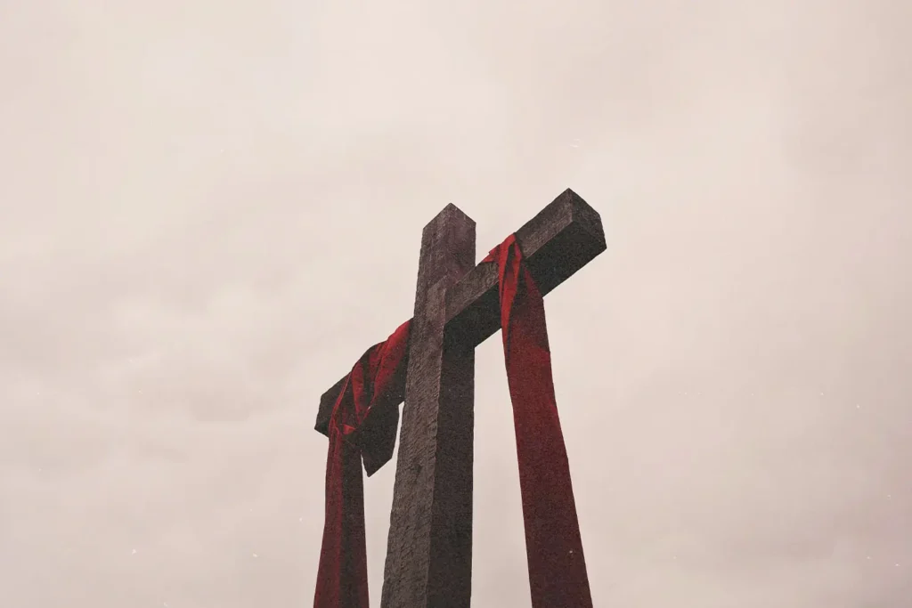 Ground view of wooden cross with red cloth draped across