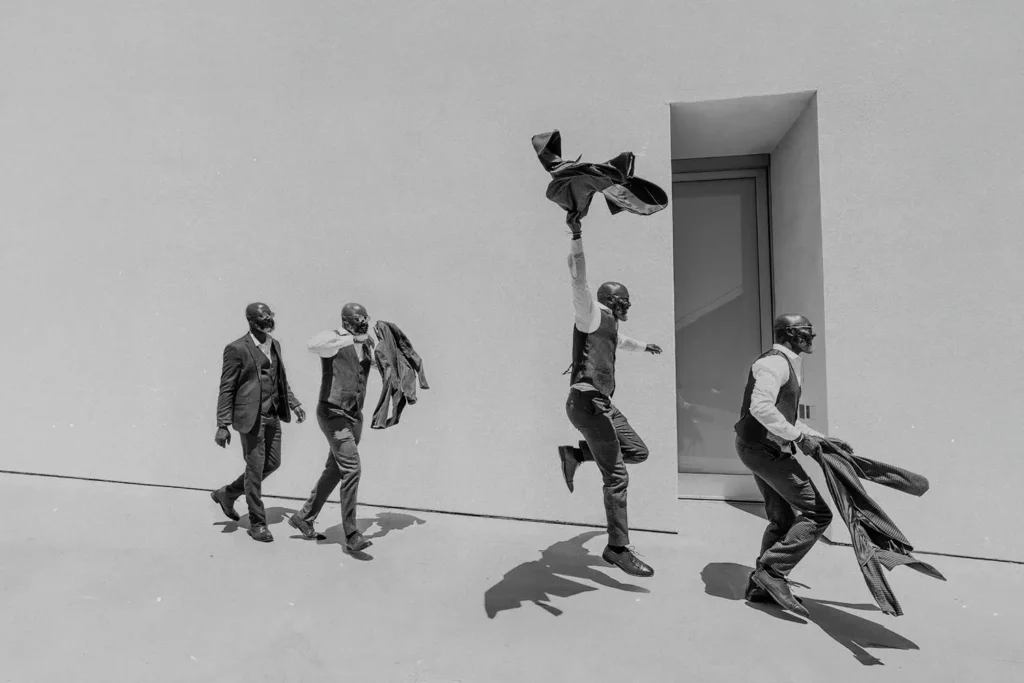 4 men in suits walking with excitement