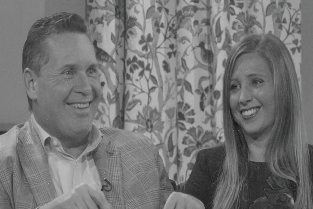 Randy Roberts and woman sitting with a smile