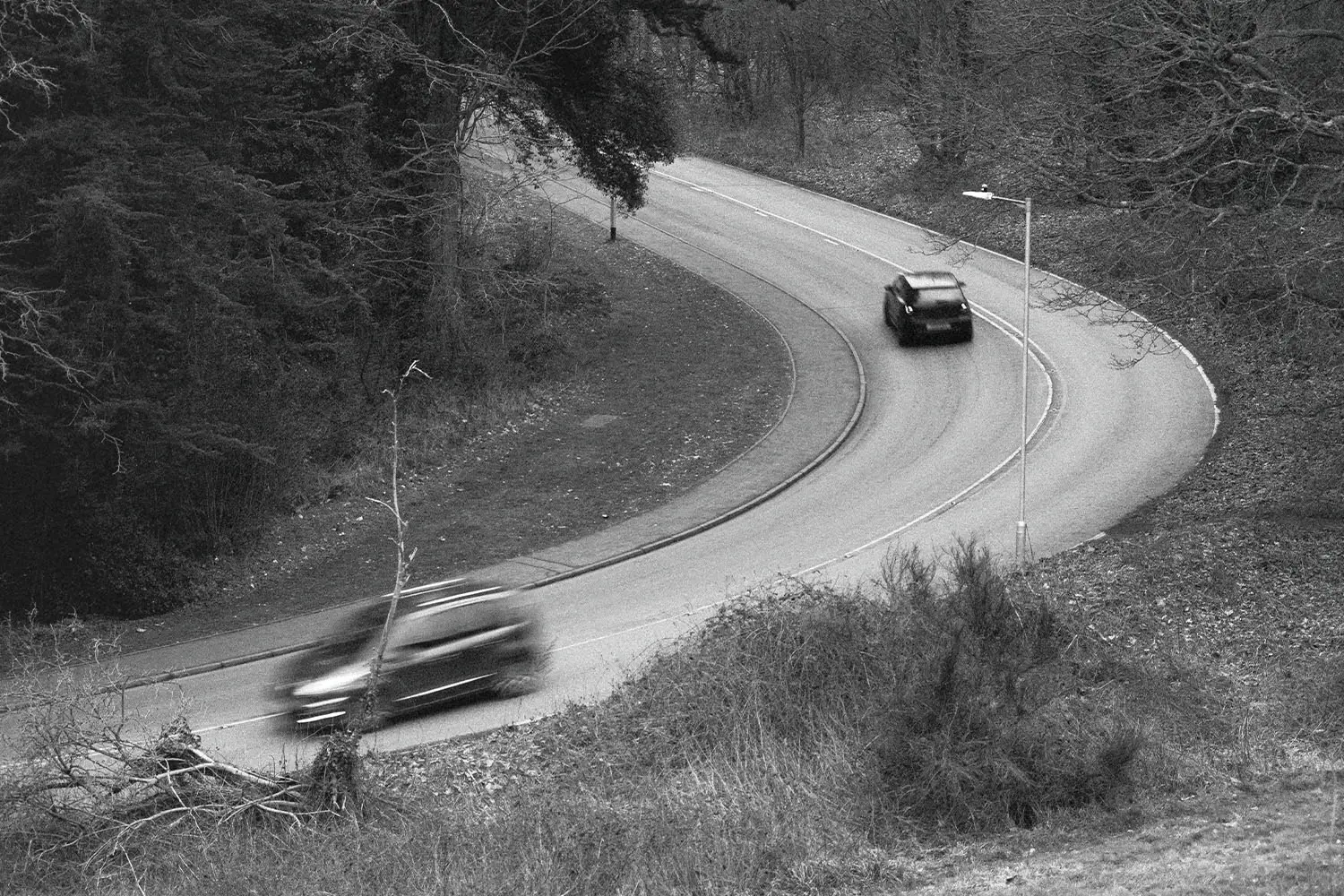 Two cars driving along a curved road