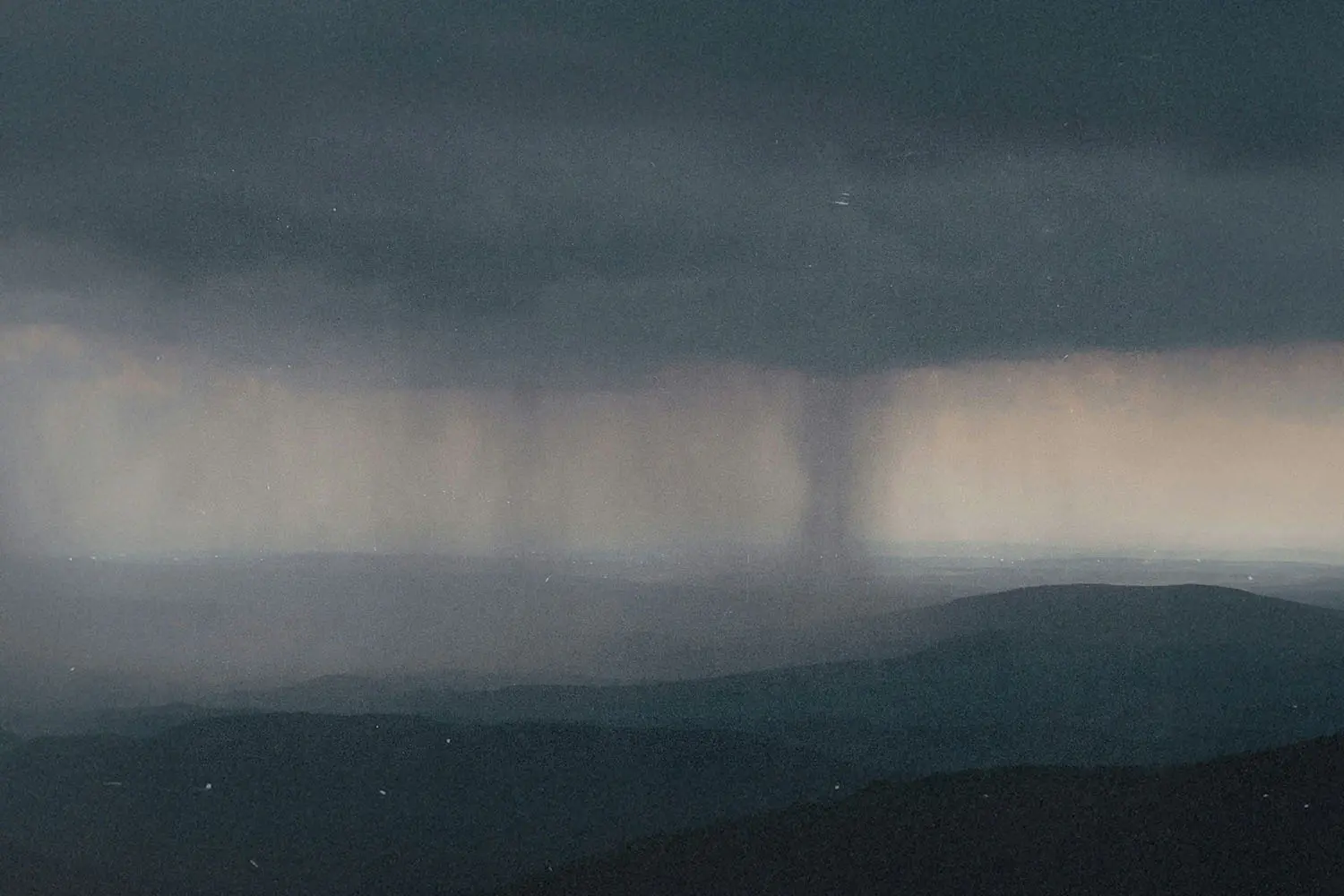 Twister forming in the background of dark gray skies