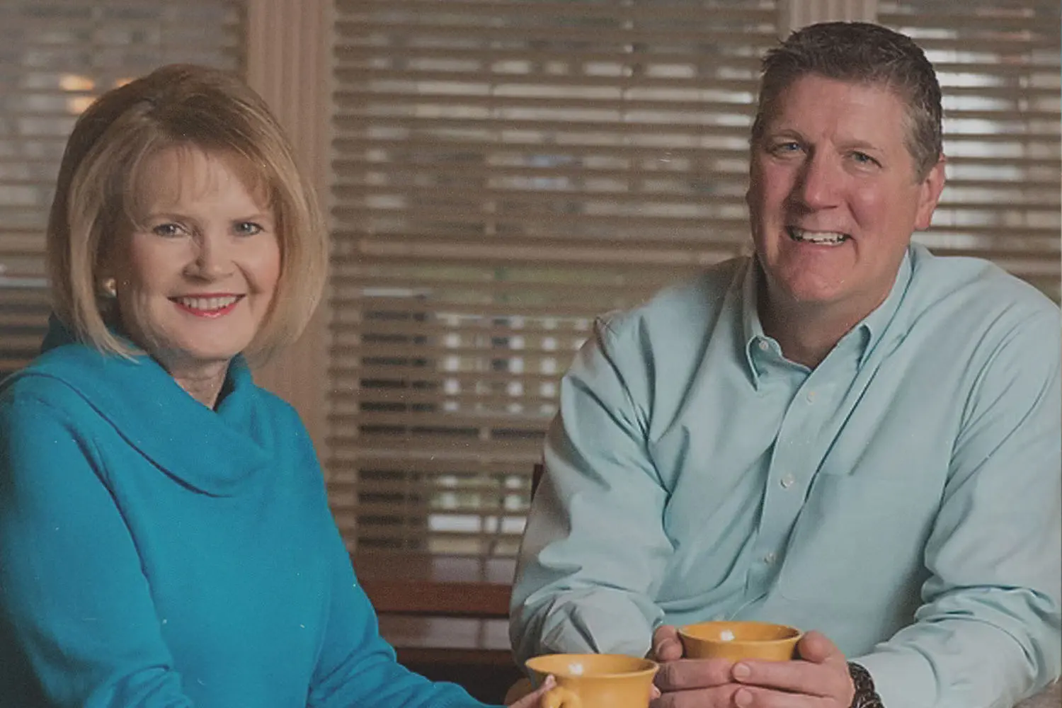 Tom and Vicki Leuther holding coffee mugs and smiling