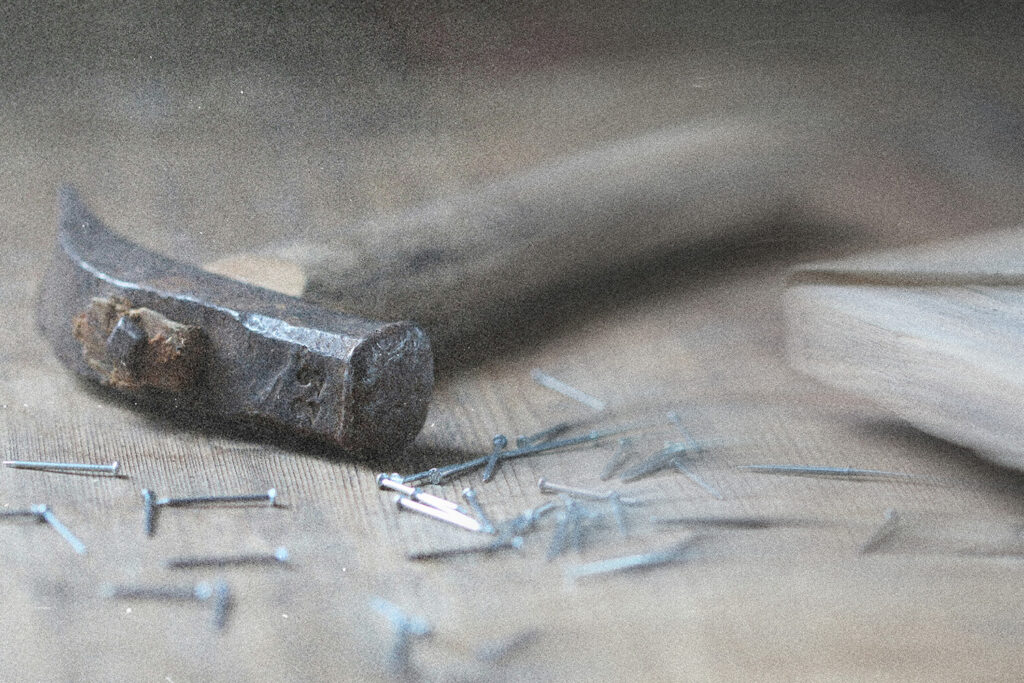 A hammer with nails on a wooden table
