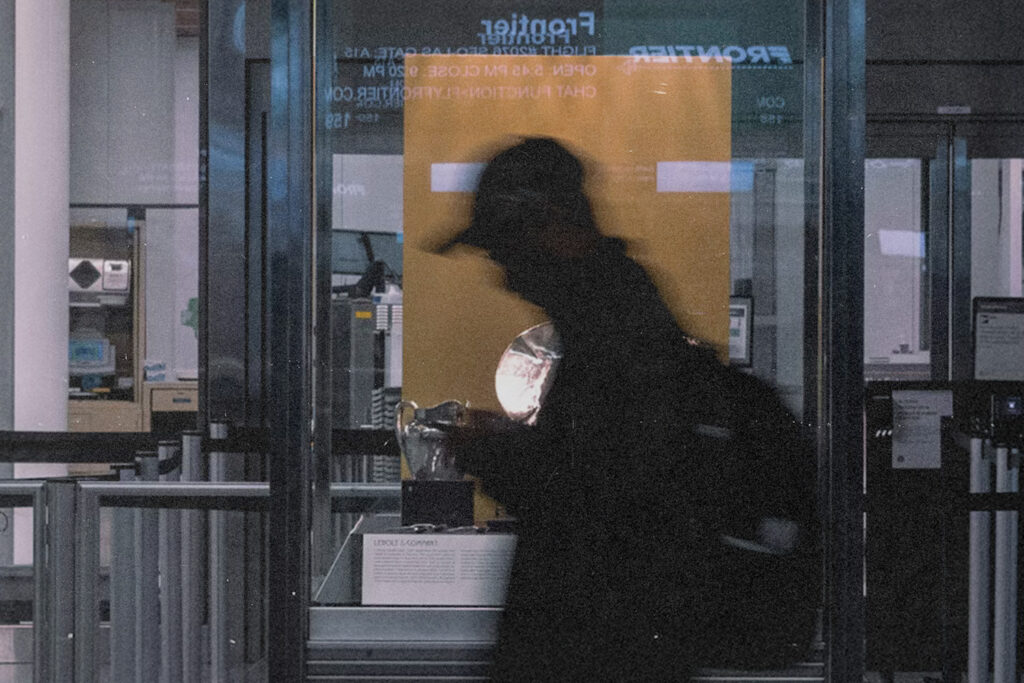 Silhouette of a traveler passing through airport security as bright scanner light glows behind, reflecting the moment tied to a supernatural healing testimony.